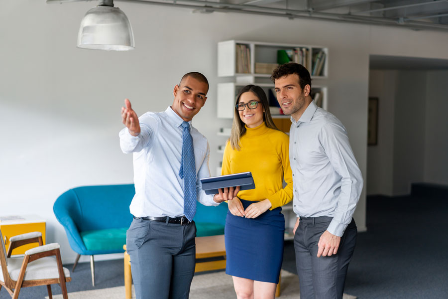 couple and a realtor showing a house